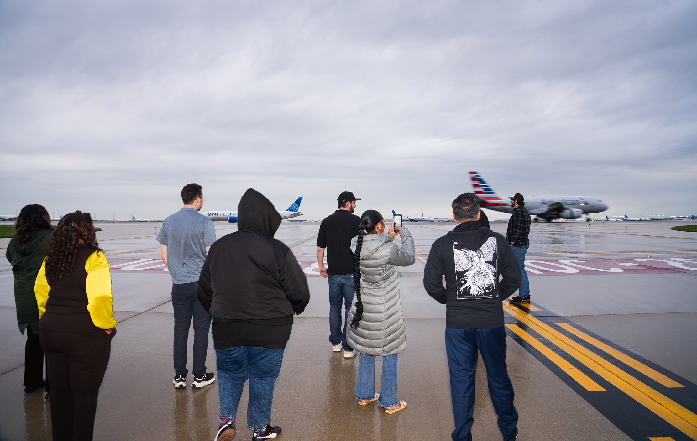 Group of students standing on the airfield during an airport tour.